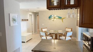 Een keuken met een eettafel, stoelen en een hanglamp.
