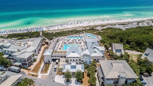An aerial view of a resort with a swimming pool, beach, and multiple buildings. - Cozy WaterColor Condo - 3rd Floor Unit, Steps to Beach Club & Seaside, Bikes! (Santa Rosa Beach)