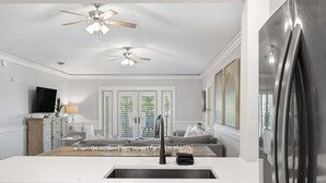 A modern kitchen with a white countertop, stainless steel appliances, and a ceiling fan. - Cozy WaterColor Condo - 3rd Floor Unit, Steps to Beach Club & Seaside, Bikes! (Santa Rosa Beach)