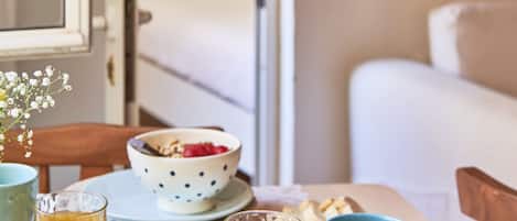 A breakfast table with a bowl of cereal, a cup of coffee, and a glass of orange juice.
