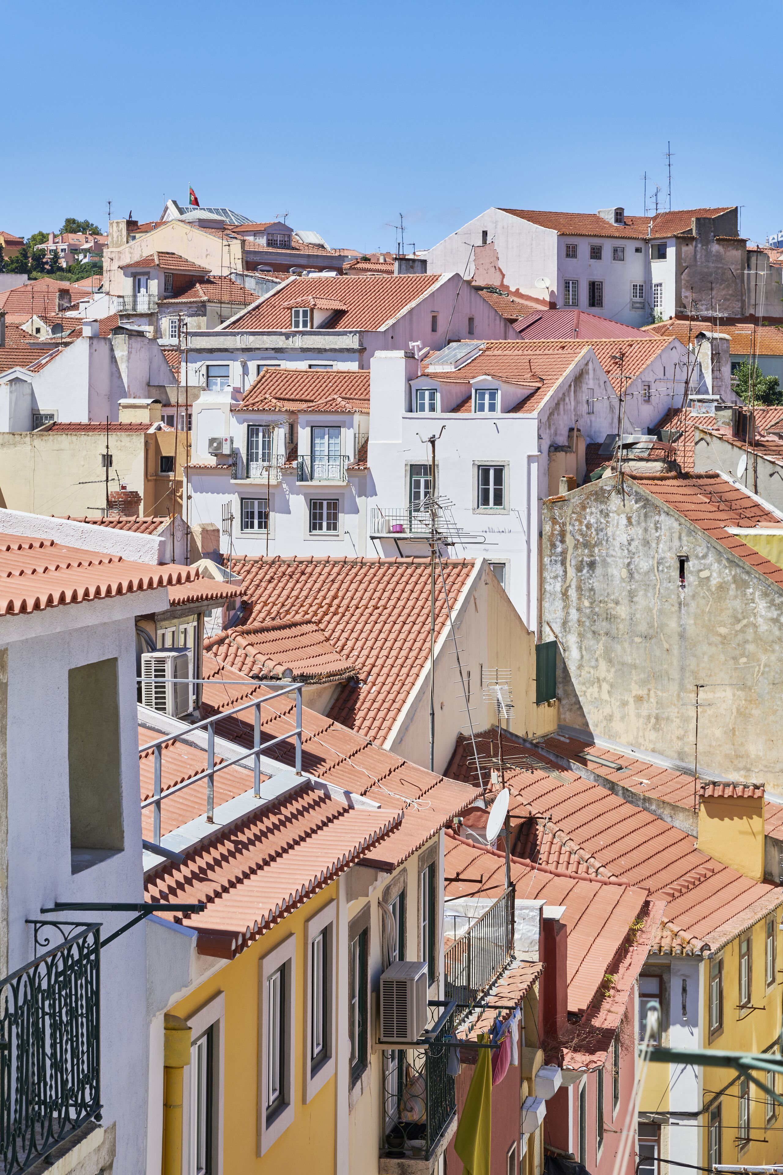 Une zone urbaine densément peuplée, avec des bâtiments très rapprochés les uns des autres, caractérisés par des toits recouverts de tuiles rouges et des balcons.