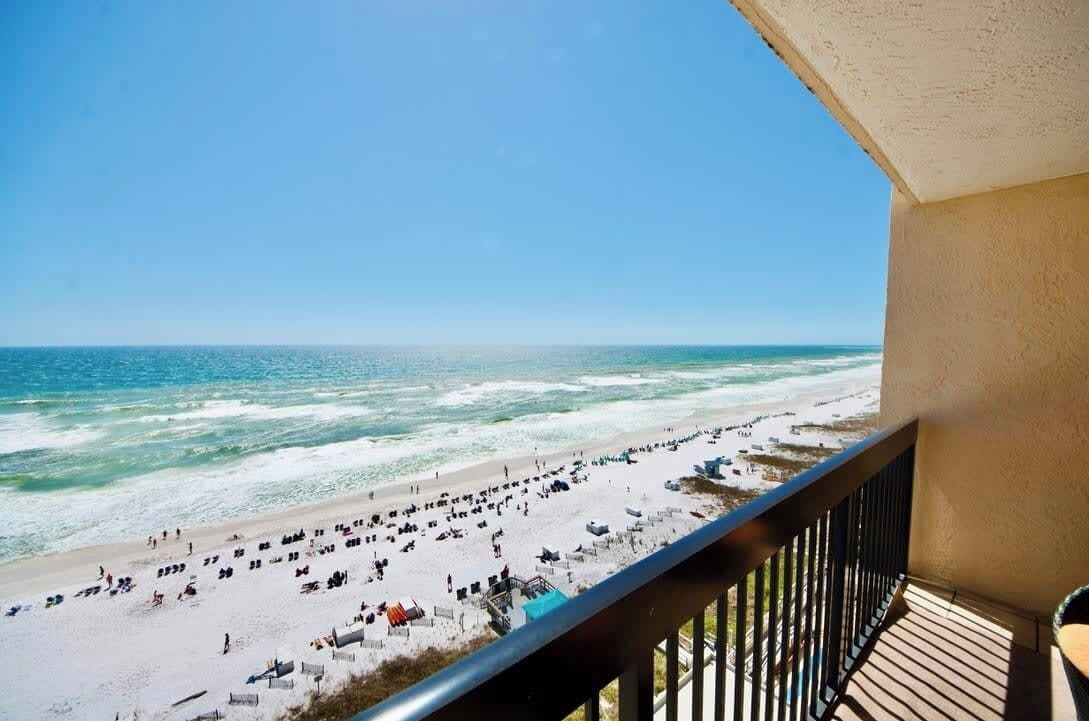 A balcony with a view of a beach and ocean.