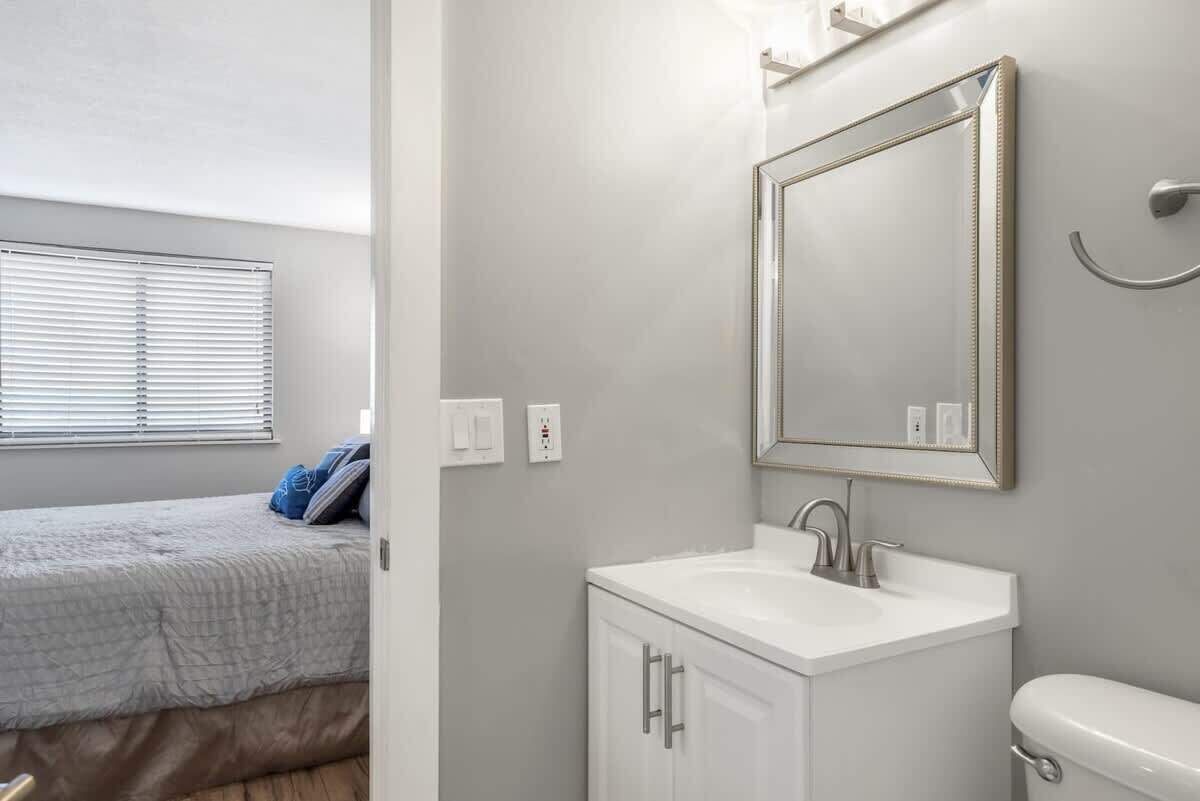 Een badkamer met een wit wastafelmeubel, een spiegel en een toilet.