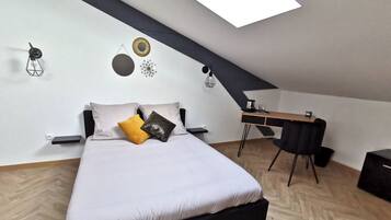 A modern bedroom with a bed, a desk, and a chair.