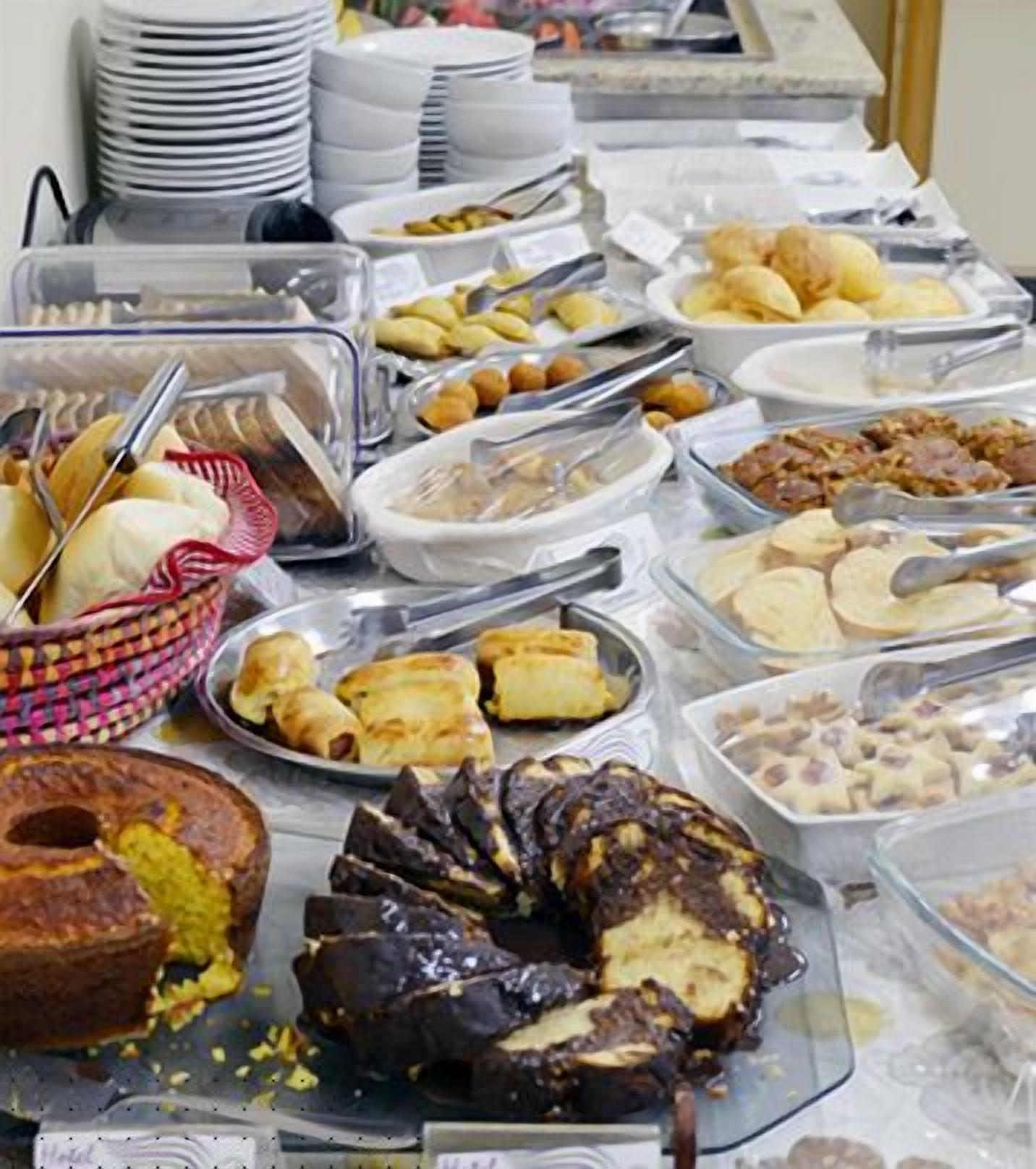 Un bufé con diversos platos, incluyendo pasteles, ensaladas y postres.