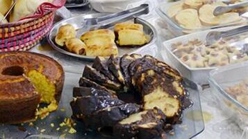 Un bufé con diversos platos, incluyendo pasteles, ensaladas y postres.