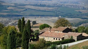 A stone building with a tiled roof, surrounded by trees and hills. - Case Belle, beautiful villa in the heart of the Val d'Orcia with 12 sleeping accommodations (Sarteano)