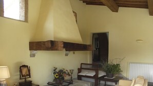 A bedroom with a wooden headboard, a bed, a nightstand with a lamp, a mirror, a vase with flowers, and a potted plant. - Case Belle, beautiful villa in the heart of the Val d'Orcia with 12 sleeping accommodations (Sarteano)