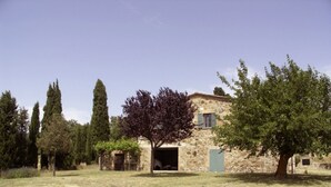 A stone building with a door and windows, surrounded by trees and grass. - Splendid villa with view in Castiglioncello sul Trinoro (Castiglioncello sul Trinoro - Sarte)