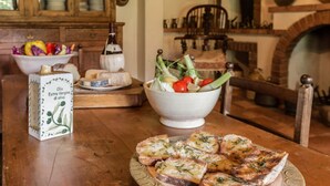A wooden table with a bowl of salad, a bottle of extra virgin olive oil, and slices of garlic bread. - Villa Roncosi, beautiful 15-bed villa with jacuzzi (Monsummano Terme)