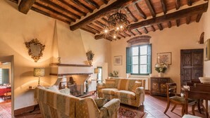A cozy living room with a fireplace, wooden beams, and traditional decor. - Villa Roncosi, beautiful 15-bed villa with jacuzzi (Monsummano Terme)
