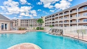 A hotel with a swimming pool, multiple balconies, and a waterfall feature. - Gorgeous Ocean Views | Ocean Park Penthouse | Garage Access | Easy Walk to Beach (Fernandina Beach)