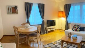 Un salon avec un canapé, une table à manger et un téléviseur.