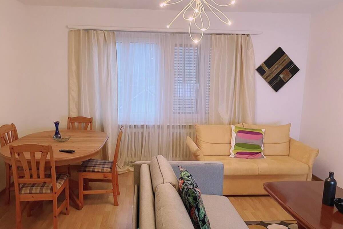 A cozy living room with a round wooden dining table, two sofas, and a coffee table.