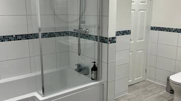 Bathtub, hair dryer, towels, toilet paper