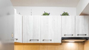 Una cocina moderna con armarios de madera, un refrigerador de acero inoxidable, horno integrado y encimera de granito.