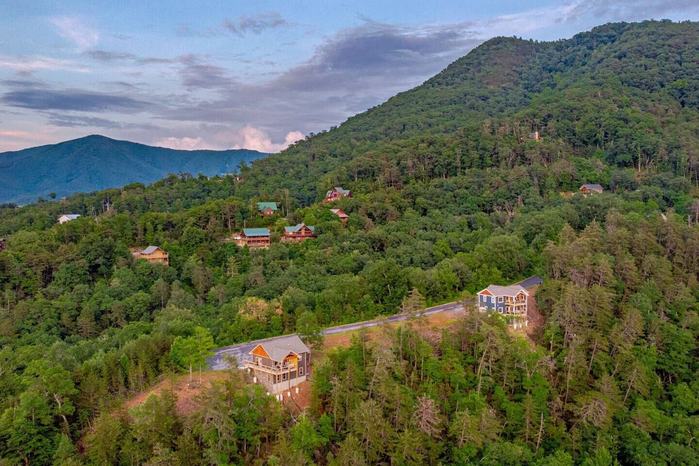 Une région montagneuse où se trouvent plusieurs maisons, toutes entourées d’une forêt dense.