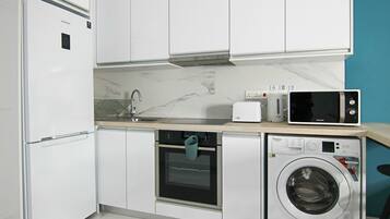 Apartemen Junior | Dapur pribadi | Lemari es, microwave, ketel listrik, dan kursi makan untuk bayi