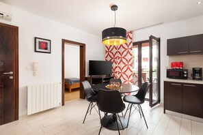Eine moderne Küche mit dunklen Schränken, einer Mikrowelle und einer Kaffeemaschine.