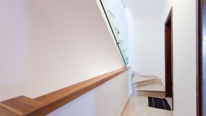 Una escalera moderna con barandilla de madera y balaustrada de vidrio.