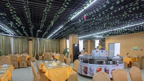 A banquet hall with tables covered in yellow tablecloths, arranged in rows. - Vienna Hotel (Huizhou Zhongkai Chenjiang Avenue) (Huizhou)