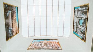 Una habitación con un ventanal grande, un techo decorado y vistas a un edificio.