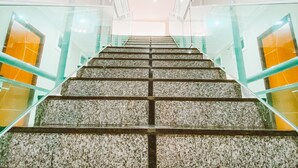 Una escalera con barandillas de vidrio y una lámpara en el techo.