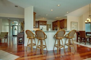 Enjoy meals in the kitchen with a central island and dining area featuring a wooden table and chairs.