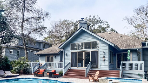 A two-story house with a swimming pool, a covered deck, and a staircase leading to the upper floor. - 3rd row updated home in Palmetto Dunes Resort, large private pool & hot tub (Hilton Head Island)