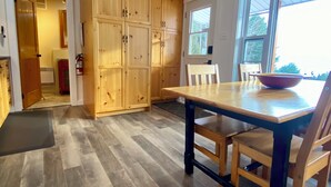 Una cocina amplia con armarios de madera, una mesa de comedor grande y vistas a través del ventanal.