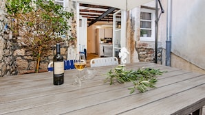 A wooden table with a bottle of wine, a glass, and a branch of greenery. - Dal Pescatore Apartment in the Old Town (Rovinj)