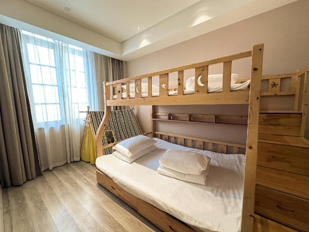 Una cama litera con estructura de madera y ropa de cama blanca.