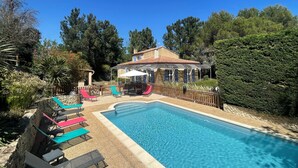 A swimming pool with lounge chairs, a covered patio, and a house with a tiled roof. - Villa 6km from St Rémy de Provence with swimming pool for 2 to 10 people (Eyragues)