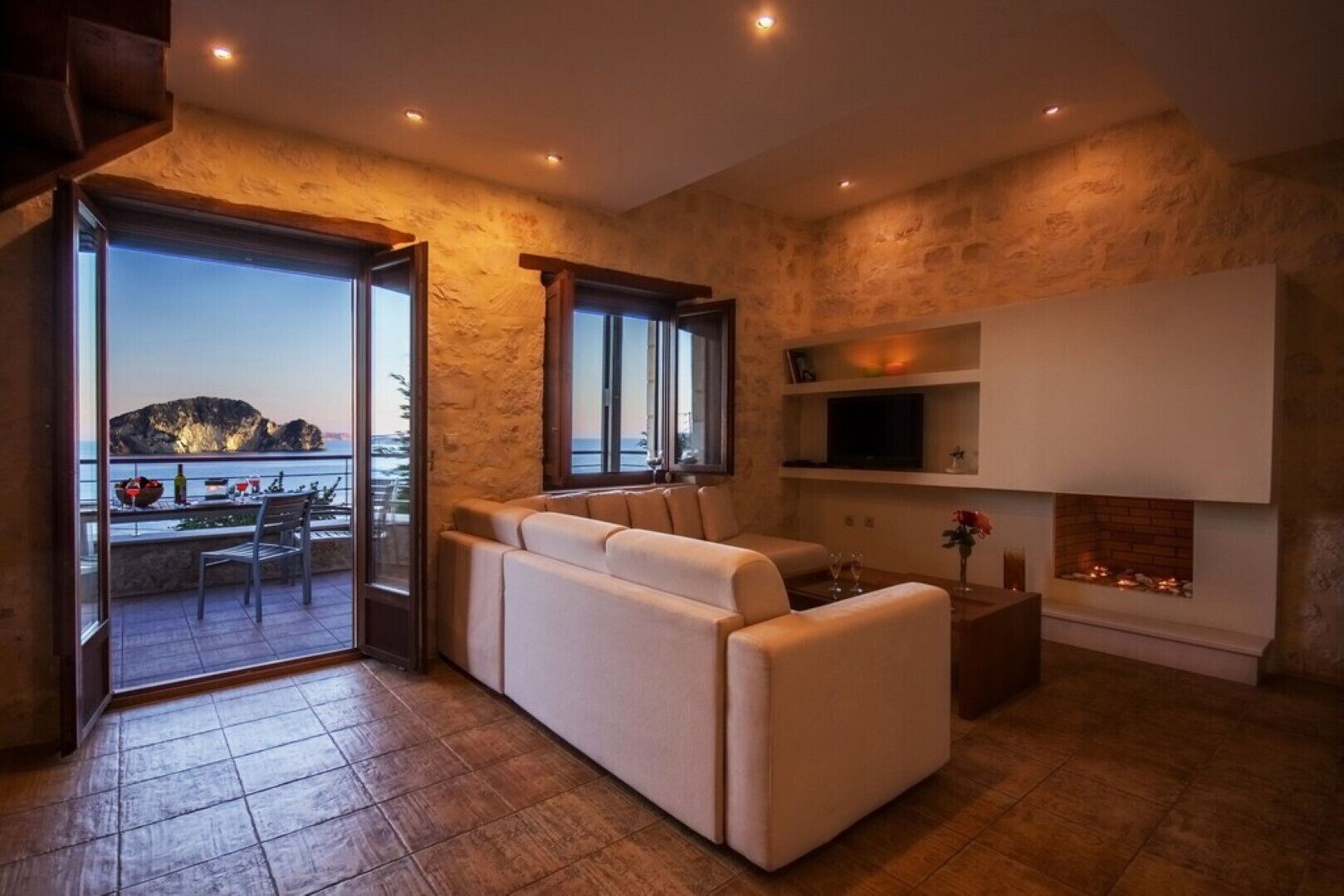 A modern living room with a sofa, a fireplace, and a TV.