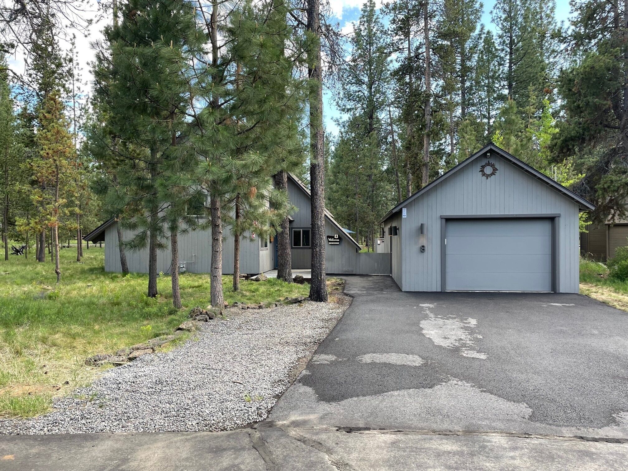A row of cabins with a gravel driveway leading to a garage.