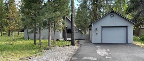 A row of cabins with a gravel driveway leading to a garage.