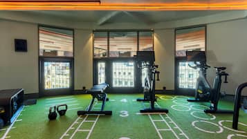 Una palestra con attrezzature per esercizi, tapis roulant e vogatore.