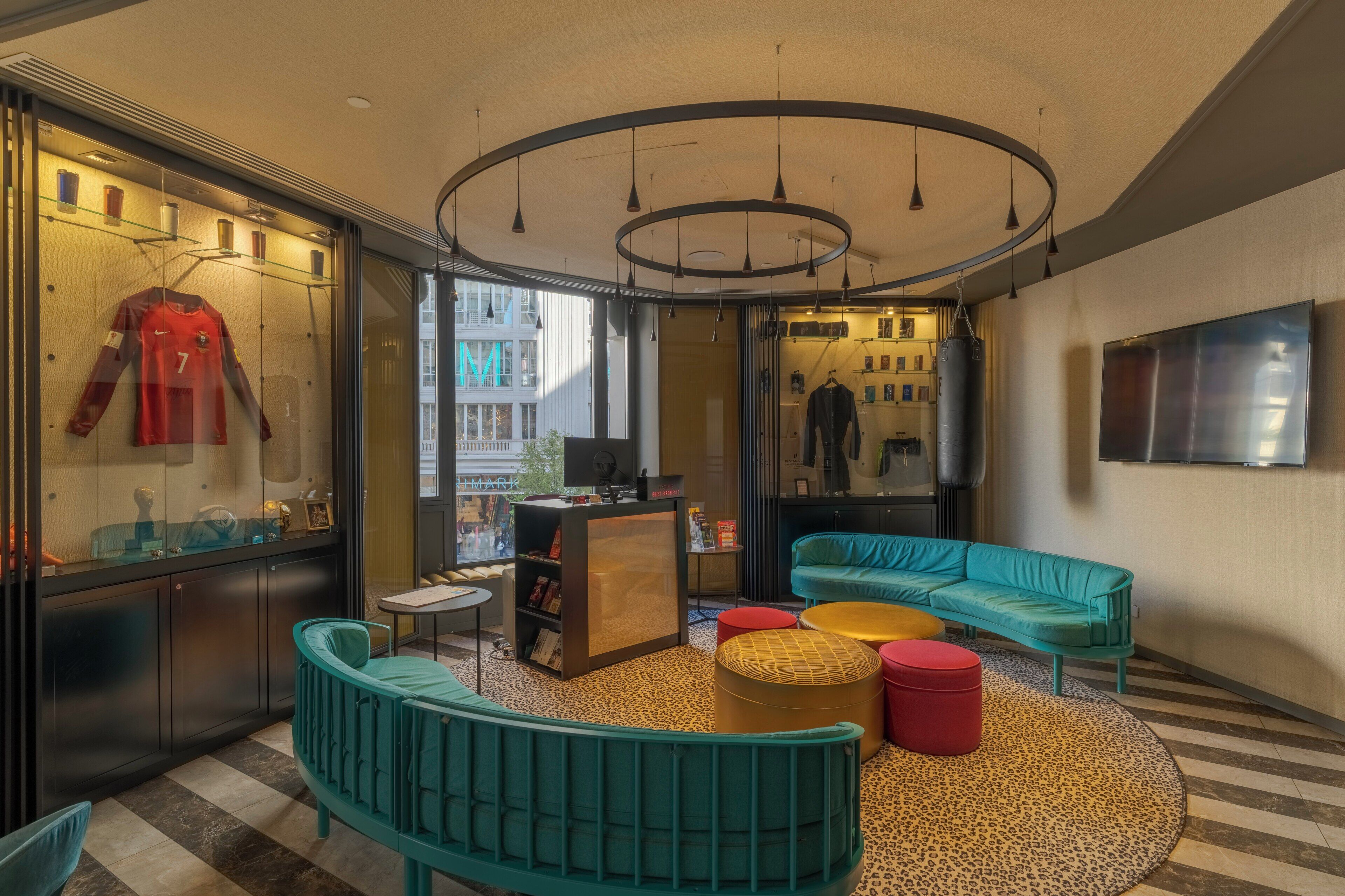 A modern interior with a curved sofa, a round coffee table, and a glass display case with sports memorabilia.