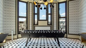 Une pièce avec un sol à motifs, un banc et un luminaire suspendu au plafond.