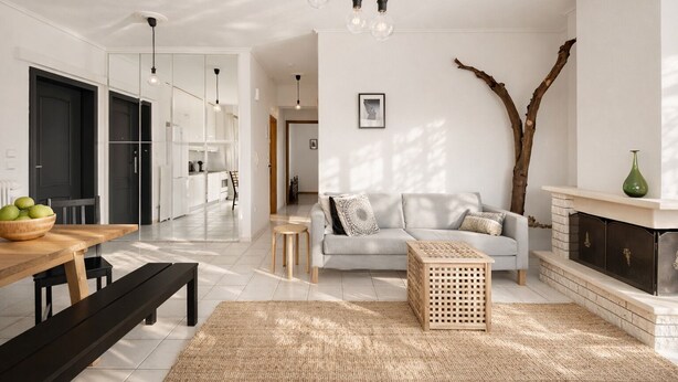 Ein modernes Wohnzimmer mit einer Couch, einem Couchtisch und einem Kamin. Es gibt einen Essbereich mit Tisch und Stühlen.