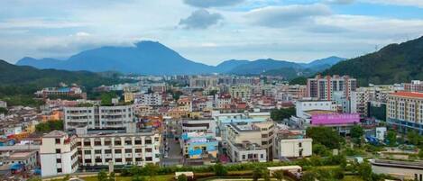 A cityscape with a mix of residential and commercial buildings, surrounded by mountains.