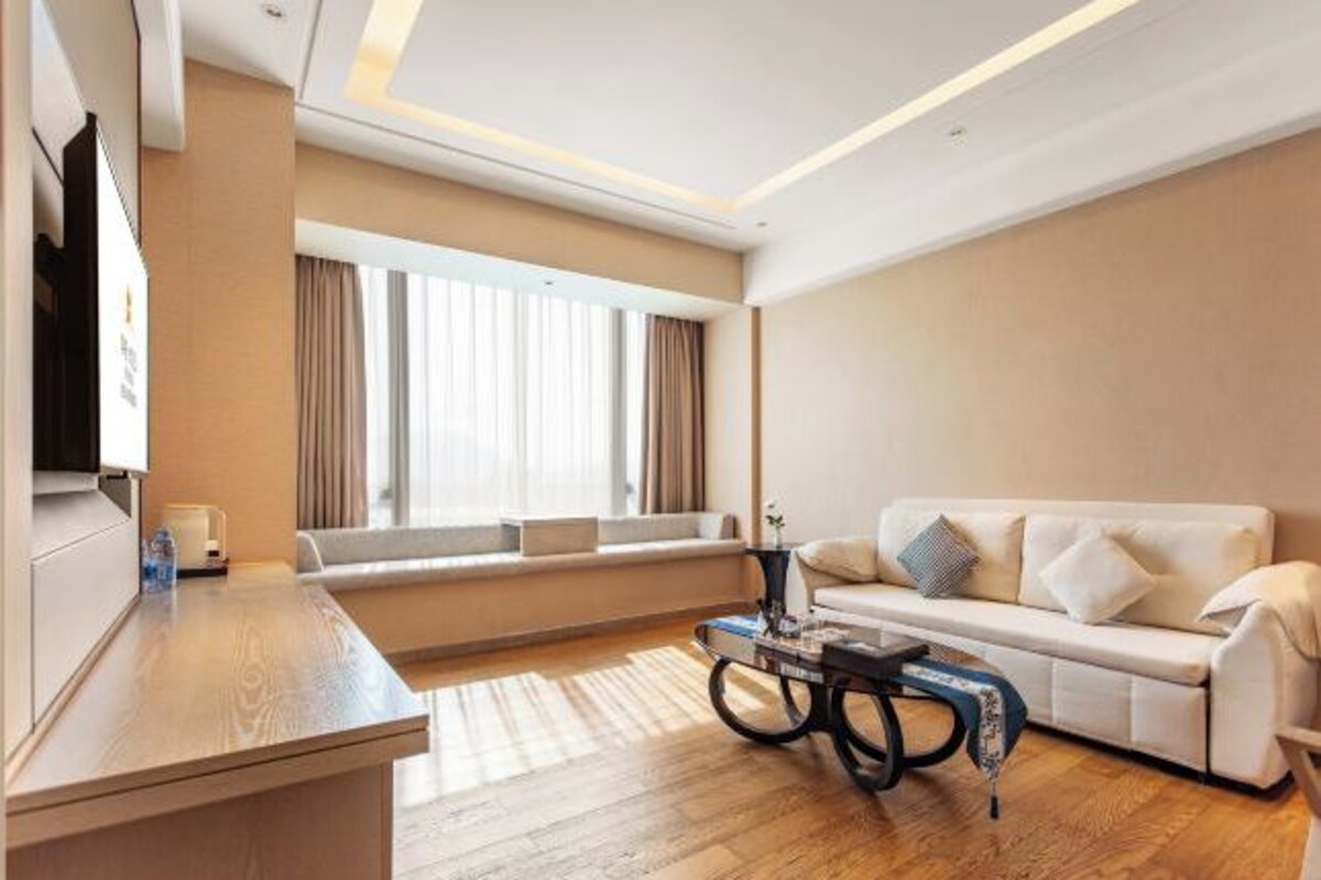 A modern living room with a sofa, a coffee table, and a TV on a stand.
