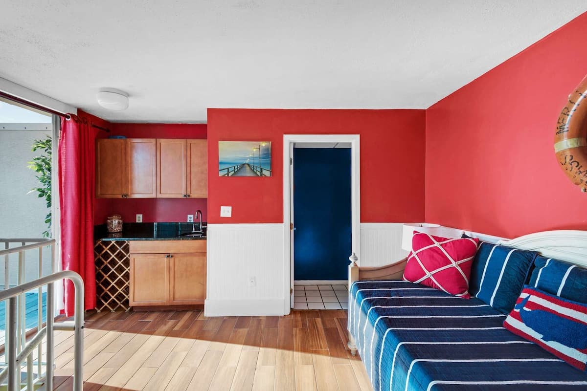 Ein kompakter Wohnraum mit Küchenzeile, Essbereich und Schlafzimmer mit Bett und Kissen.