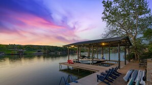 A lakeside dock with a covered seating area, a boat, and paddleboards. - Private Boat Slip| Lakefront | Putting Green | Firepit (Burnet)