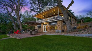 A two-story house with a covered patio, stone exterior, and large windows. - Private Boat Slip| Lakefront | Putting Green | Firepit (Burnet)