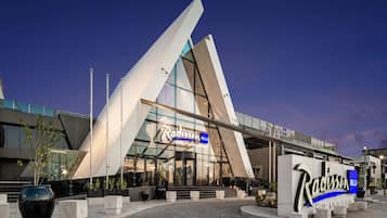 Hotel Radisson Blu con diseño arquitectónico moderno, destacando una fachada de vidrio prominente y una estructura angular distintiva.