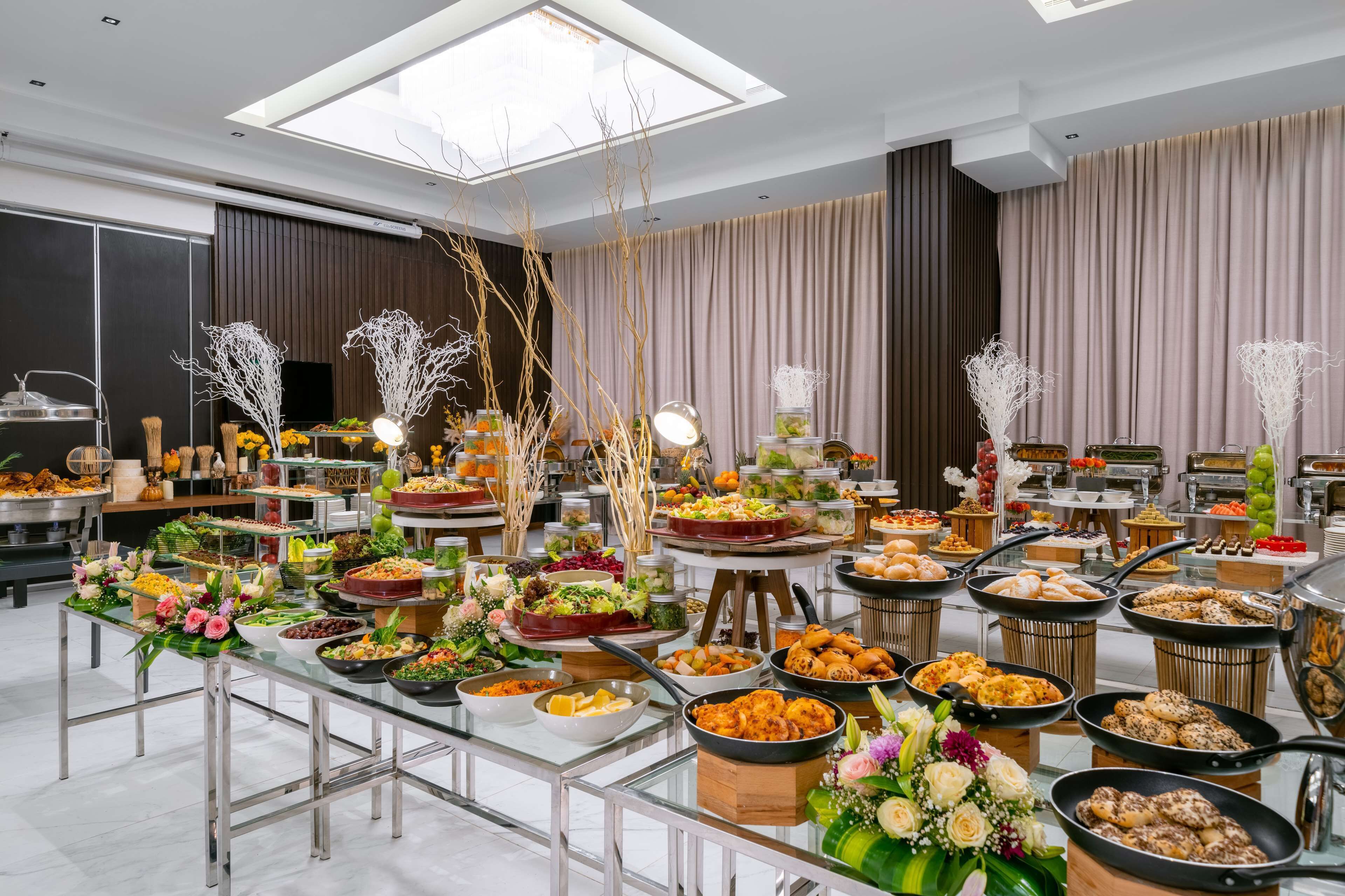 A buffet setup with various food items and decorative elements.