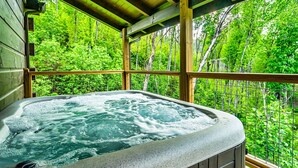 Un bain à remous dans un chalet en bois avec vue sur une forêt.