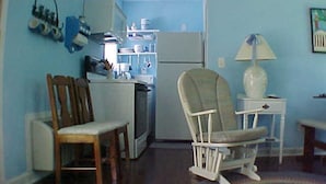 A compact living space with a kitchenette, a dining area with a chair, and a small table. - Tarheel Retreat (Henderson)