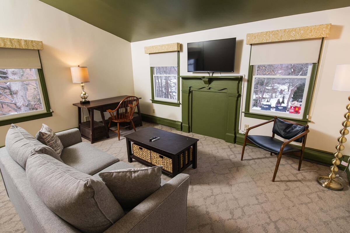 A living room with a sofa, a coffee table, a TV, and a chair.